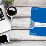 Copy of RASSO 2025, 5 year plan on a desk top, with coffee, a phone and laptop