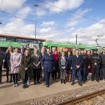Tram and bus wrapped in the A-Z of Consent, with the people responsible for this stood in front of it looking happpy